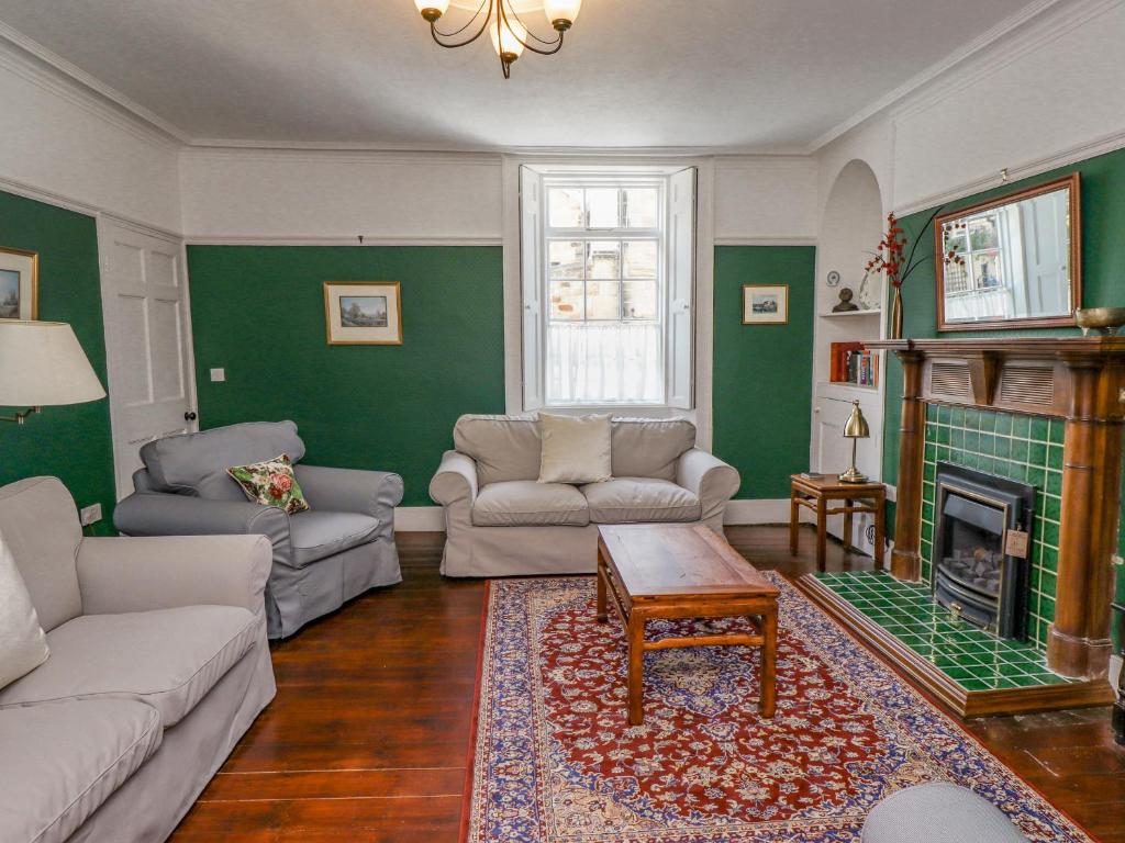 a living room with a couch and a fireplace at Victoria House in Alnwick