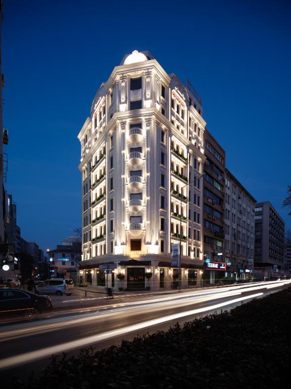a tall white building on a city street at night at Perla Pura in İzmir