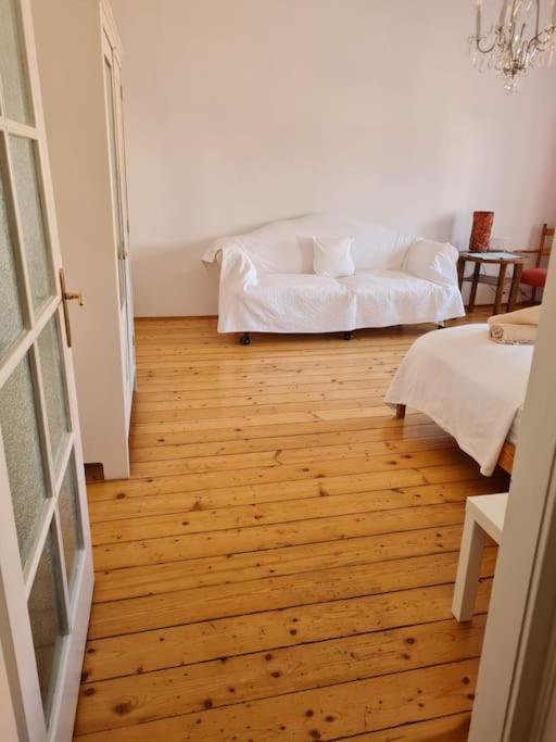 una camera con pavimento in legno e divano bianco di Chic 1-BR Apartment - Perfect Location a Vienna