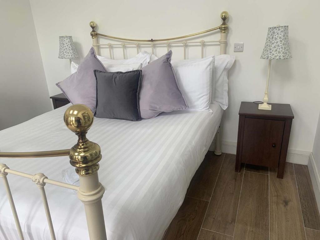 a bedroom with a bed with purple and white pillows at Bayview, Dunmore East, County Waterford - Sleeps 12 persons in Dunmore East
