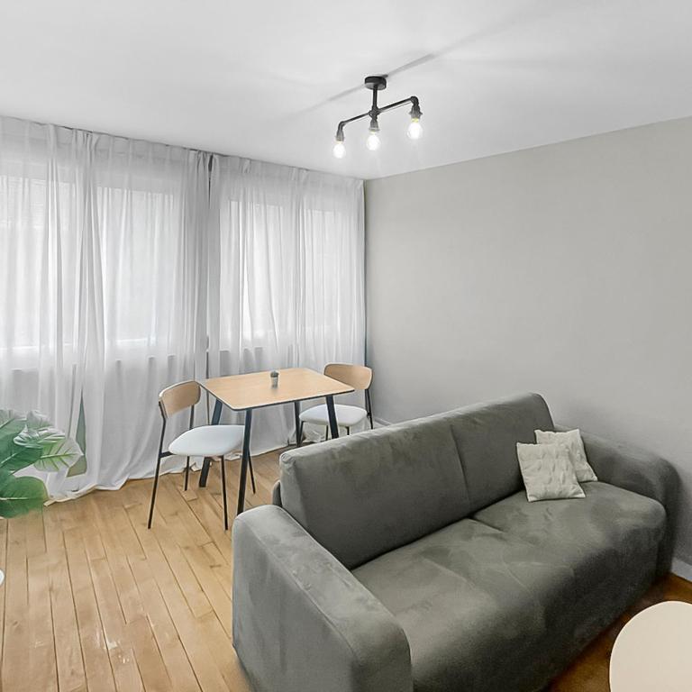 un salon avec un canapé et une table dans l'établissement L'Odyssée Nazairienne, à Saint-Nazaire