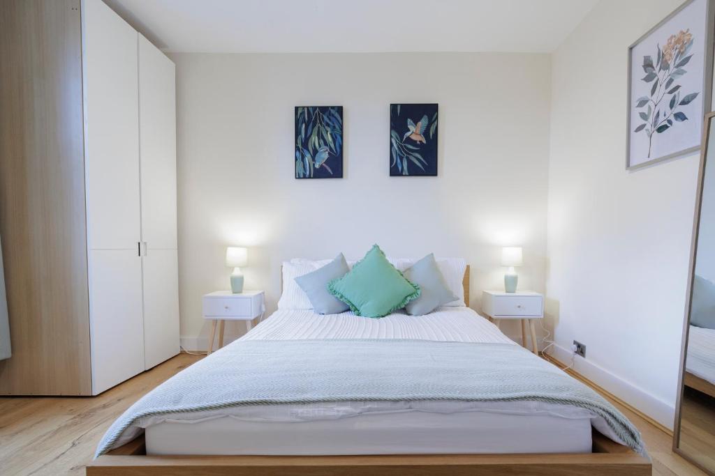 a bedroom with a large bed with two night stands at Luxury Apartment in Kensal Rise in London