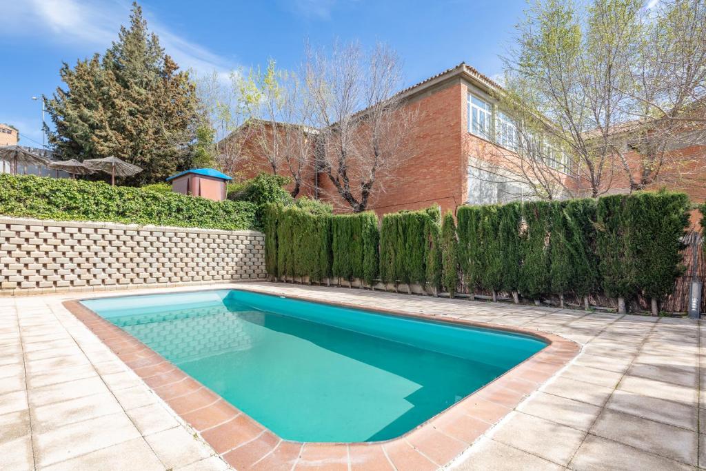 a swimming pool in a yard next to a fence at Eurostars Toledo in Toledo