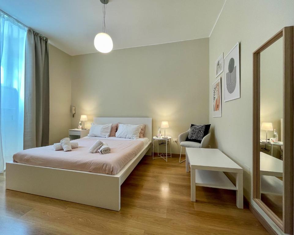 a white bedroom with a bed and a chair at Policlinico Apartment in Rome