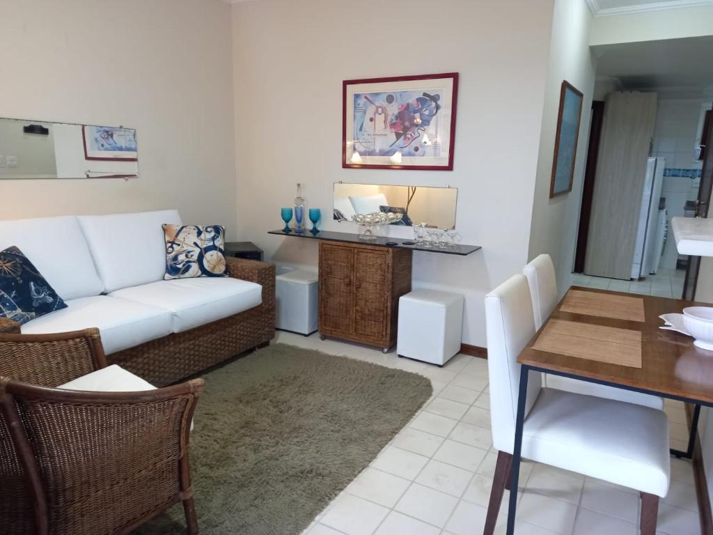 a living room with a couch and a table at Flat Bairro Nobre - Bertioga in Bertioga
