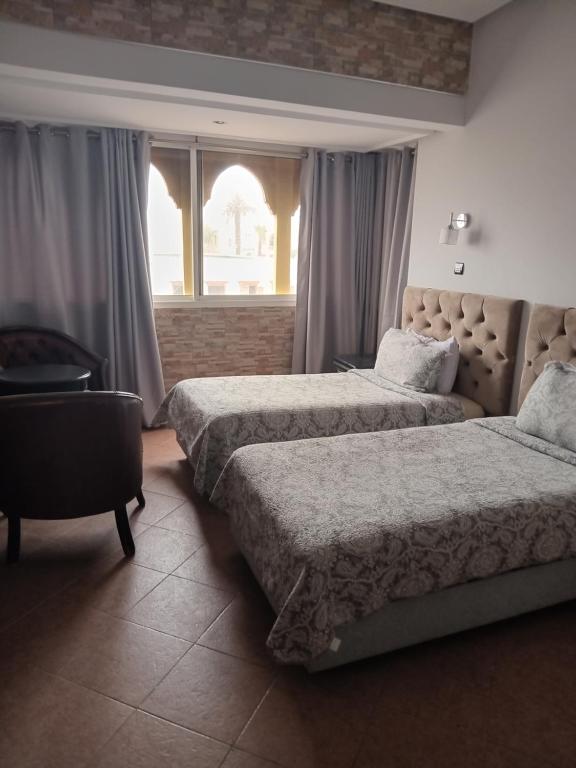 a hotel room with two beds and a window at Hotel Darna in Rabat