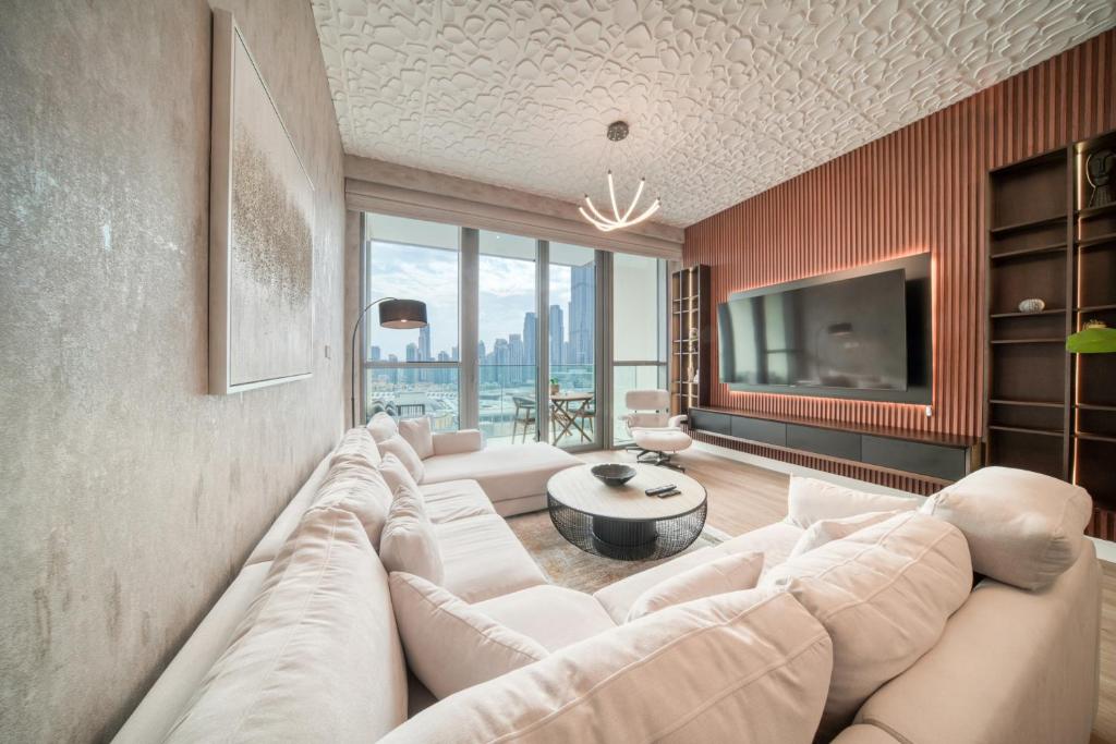 a living room with a large couch and a tv at Downtown Views I - Burj Khalifa View, Downtown Dubai in Dubai
