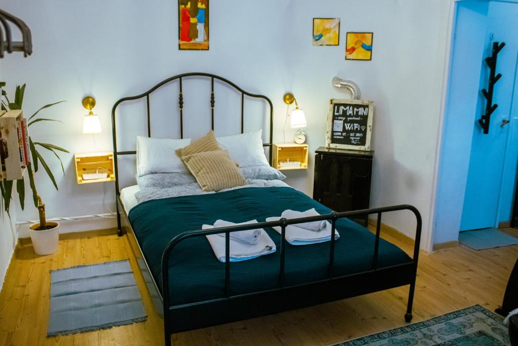 a bedroom with a bed with a green comforter at Lima Mini - cozy apartment - in Győr