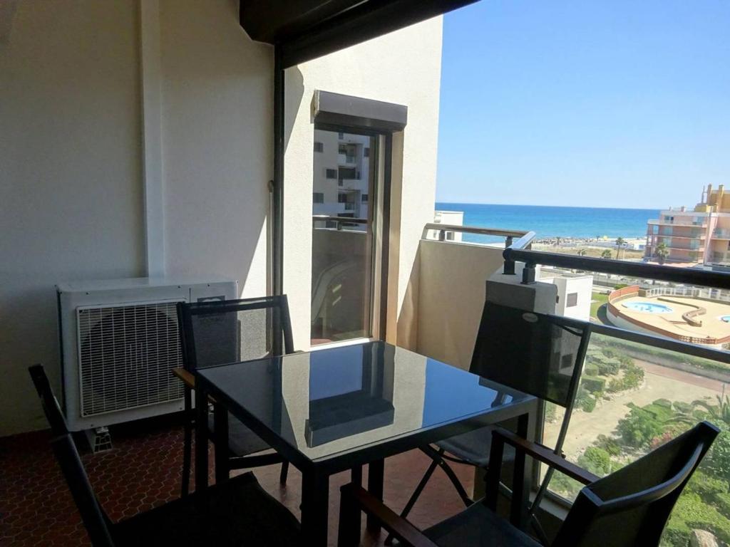 une table et des chaises sur un balcon avec vue sur l'océan dans l'établissement Appartement 2 pièces avec terrasse au bord de l'eau, parking, climatisation - FR-1-782-1, au Barcarès