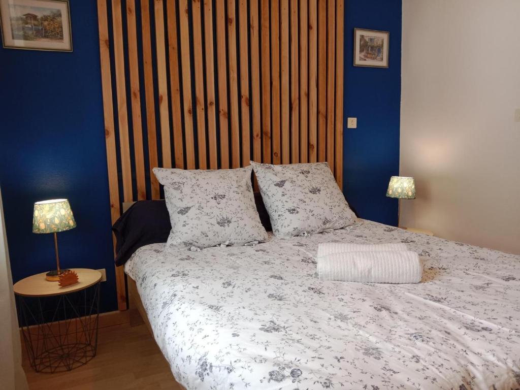 a bedroom with a large bed with blue walls at Gîte Bellerive-sur-Allier, 4 pièces, 6 personnes - FR-1-489-481 in Bellerive-sur-Allier