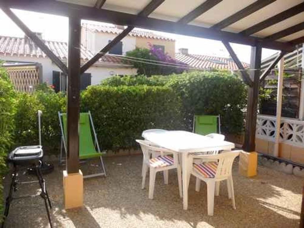 un patio avec une table, des chaises et un barbecue dans l'établissement Villa T2 avec terrasse, parking et climatisation à 800m de la plage - FR-1-782-11, au Barcarès