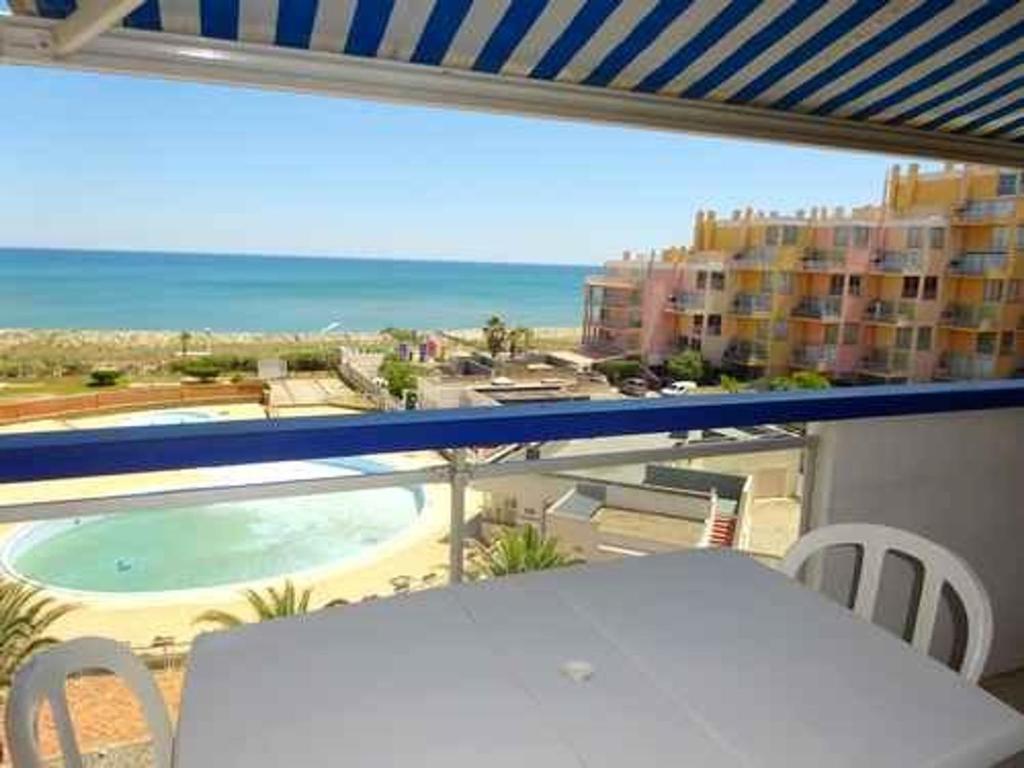 un balcon avec une table et une vue sur l'océan dans l'établissement Appartement 2/3 pièces avec piscine, tennis et parking privé, proche commerces - FR-1-782-43, au Barcarès