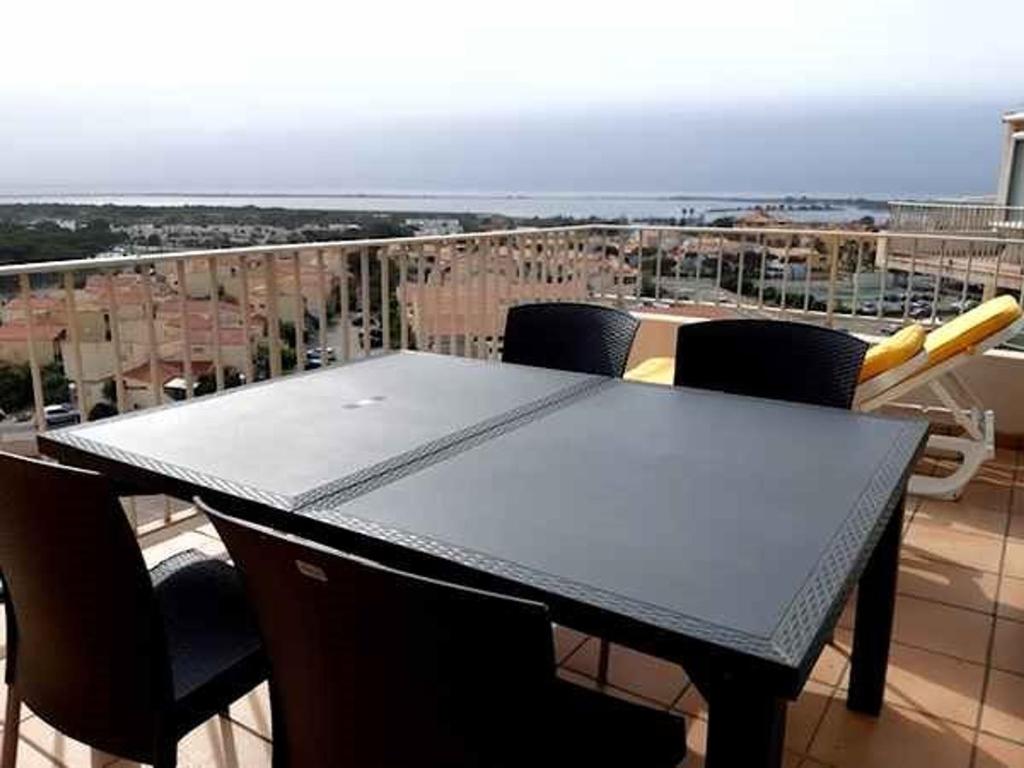 - un balcon avec une table et des chaises dans l'établissement Duplex avec parking privé, ascenseur, accès plage et WiFi - 2 chambres - FR-1-782-44, au Barcarès
