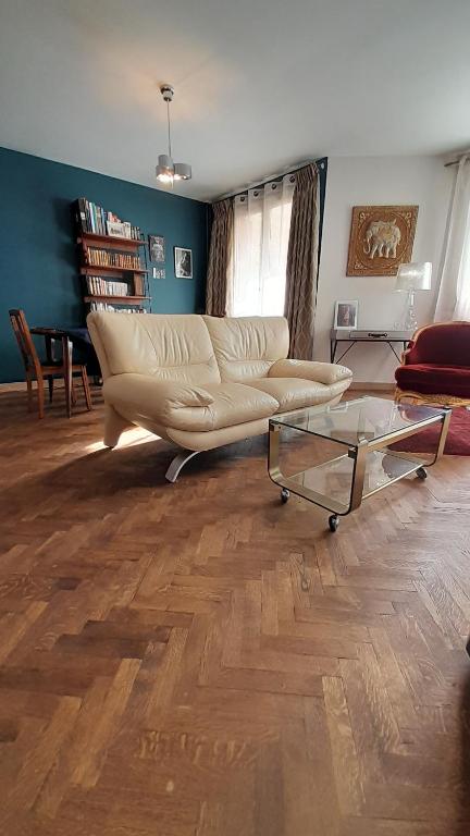 a living room with a couch and a glass table at Comfy Appartement 85m2 in a calm area in Montreuil 10min from Paris in Montreuil