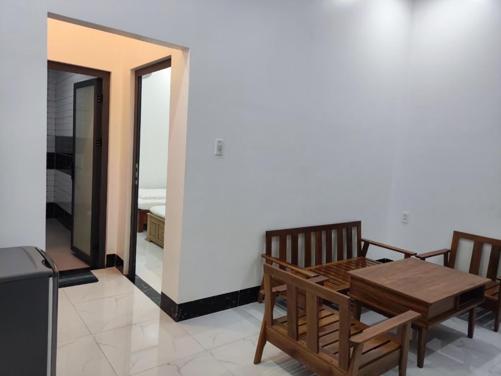 - une salle à manger avec une table en bois et 2 chaises dans l'établissement NEW WAVE HOMESTAY, à Ấp Khánh Phước (1)
