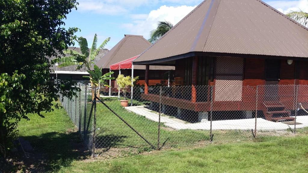 un bâtiment avec une clôture devant lui dans l'établissement Raiatea Airport Bungalow, à Uturoa