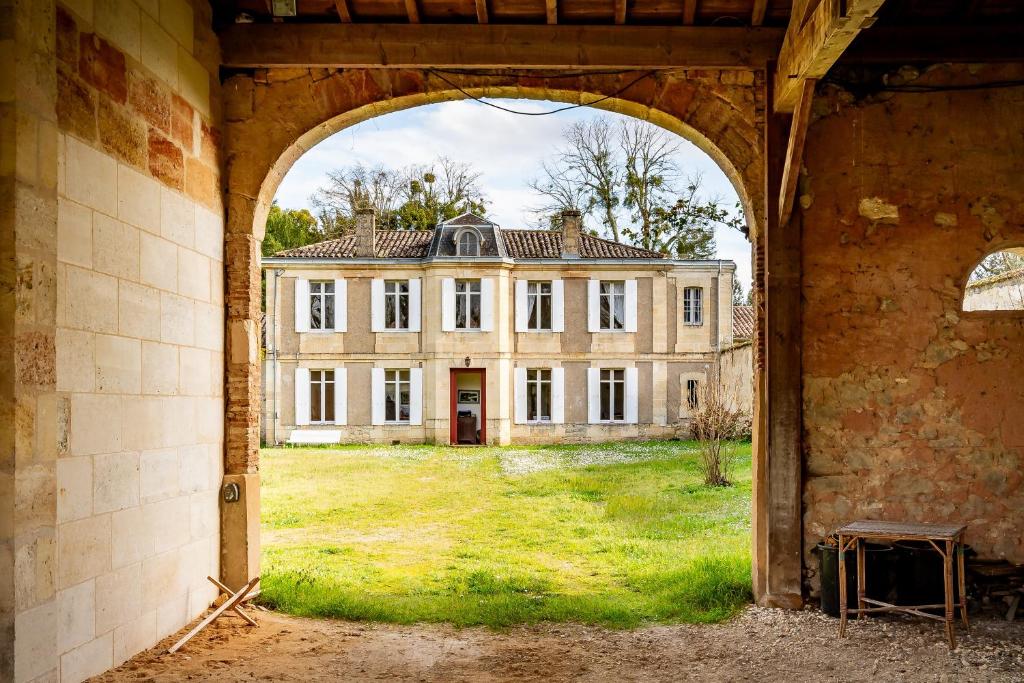 una vista al arco de una casa antigua a través de un edificio en Sorbède - Charmante maison pour 13 personnes, en Montussan