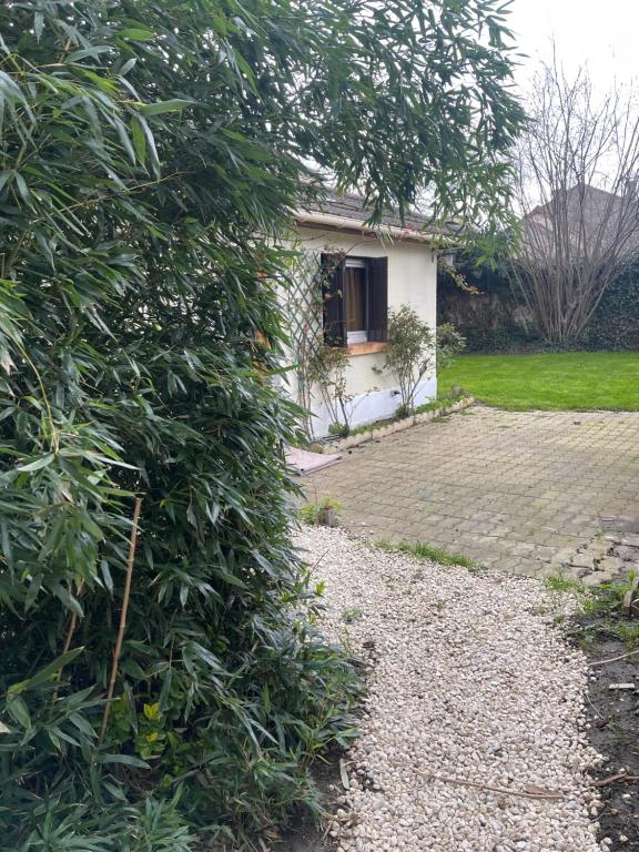 une maison avec une grande brousse devant une cour dans l'établissement Dar Kareem, à Villeparisis