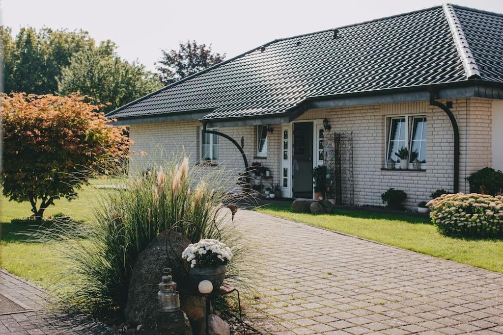 a small house with a brick driveway in front of it at Bungalow mit Basketballplatz in Lemgo