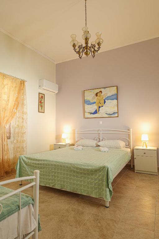 a bedroom with a green bed and a chandelier at Aneza in Kremasti