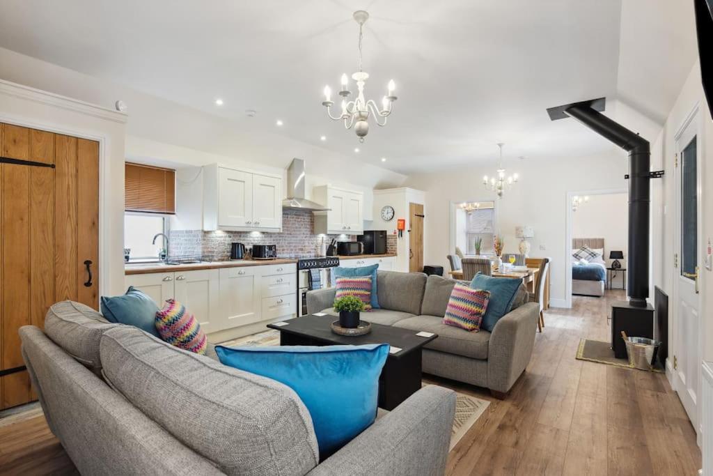 a living room with two couches and a kitchen at East Cottage rural country haven in Radernie