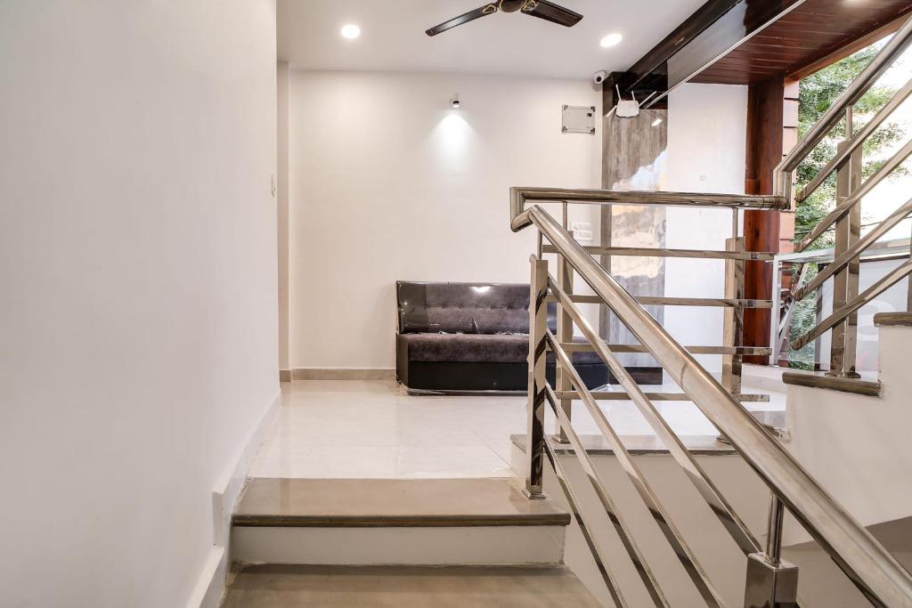 eine Treppe in einem Wohnzimmer mit Sofa in der Unterkunft Super OYO Flagship Hotel Trisha's in Bhopal