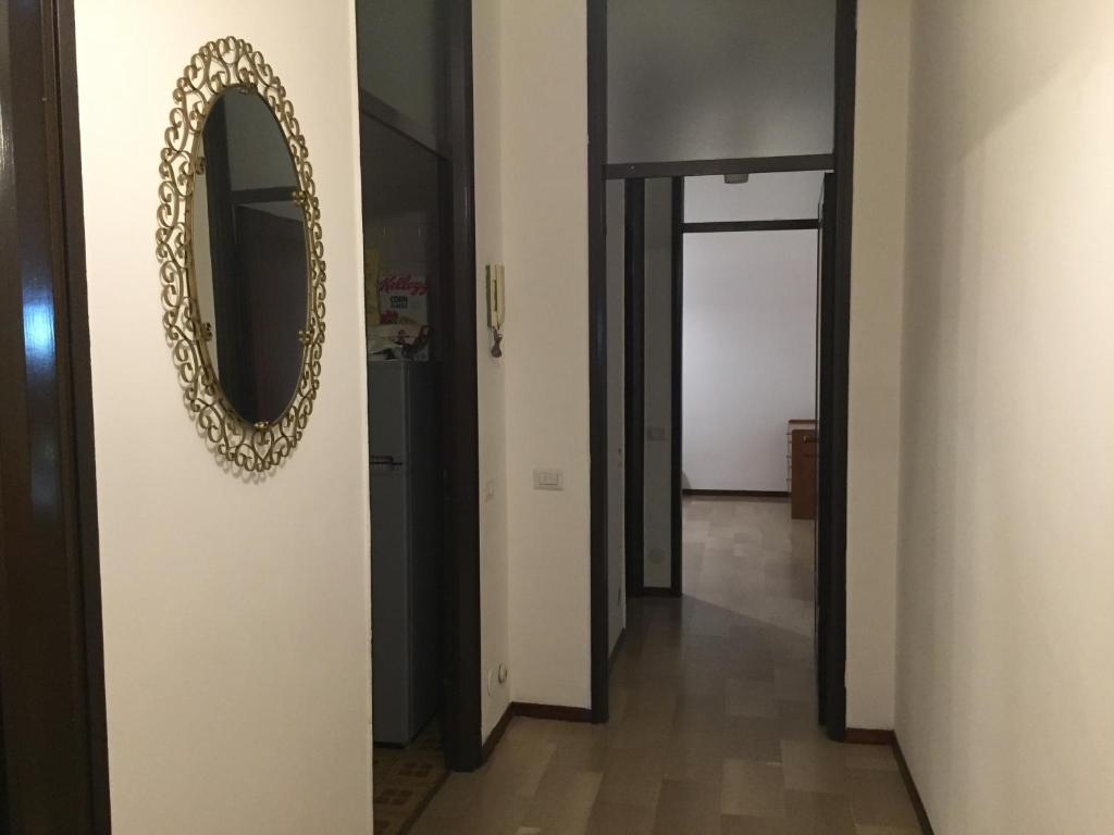 einen Flur mit einem Spiegel an einer Wand und einer Tür in der Unterkunft Bellini Apartment's in Novara