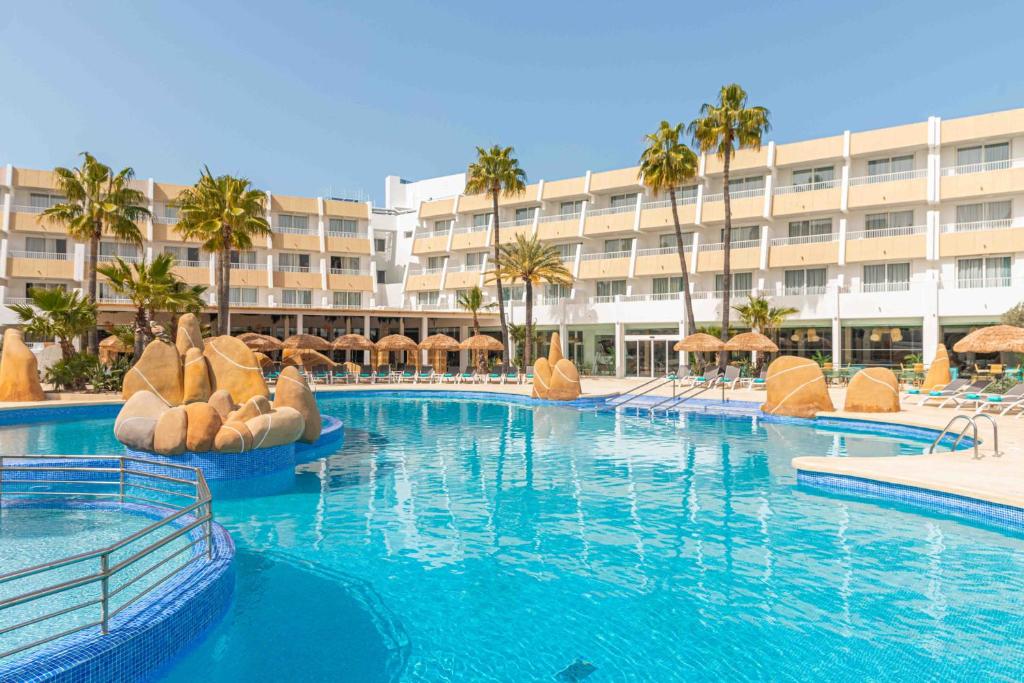 una gran piscina con un hotel en el fondo en MarSenses Rosa del Mar Hotel & Spa, en Palmanova