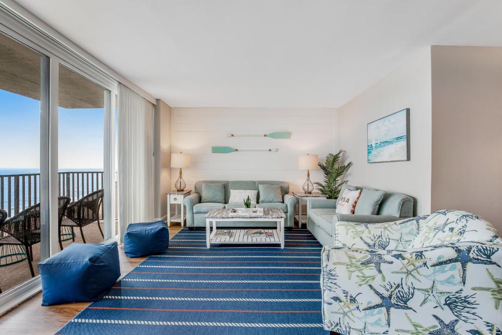 a living room with blue furniture and a balcony at Sea Colony - 1403N Edgewater House Rd. in Bethany Beach