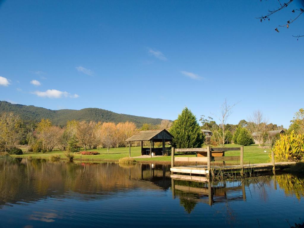a gazebo next to a lake with a dock at Sanctuary Park Cottages in Healesville