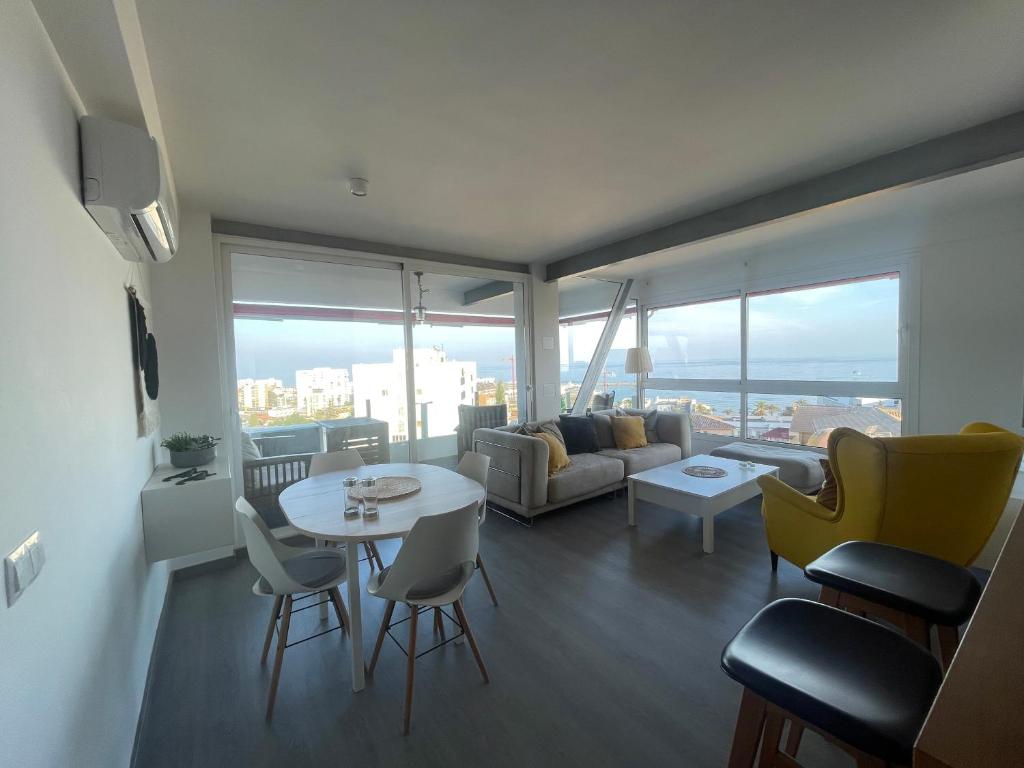 ein Wohnzimmer mit einem Sofa, einem Tisch und Stühlen in der Unterkunft Apartamento en urbanización con fantásticas vistas in Benalmádena