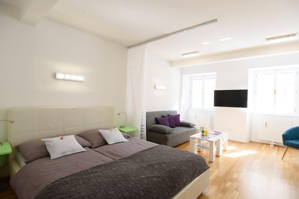 a bedroom with a large bed and a couch at Designer apartment - centrally located in Vienna