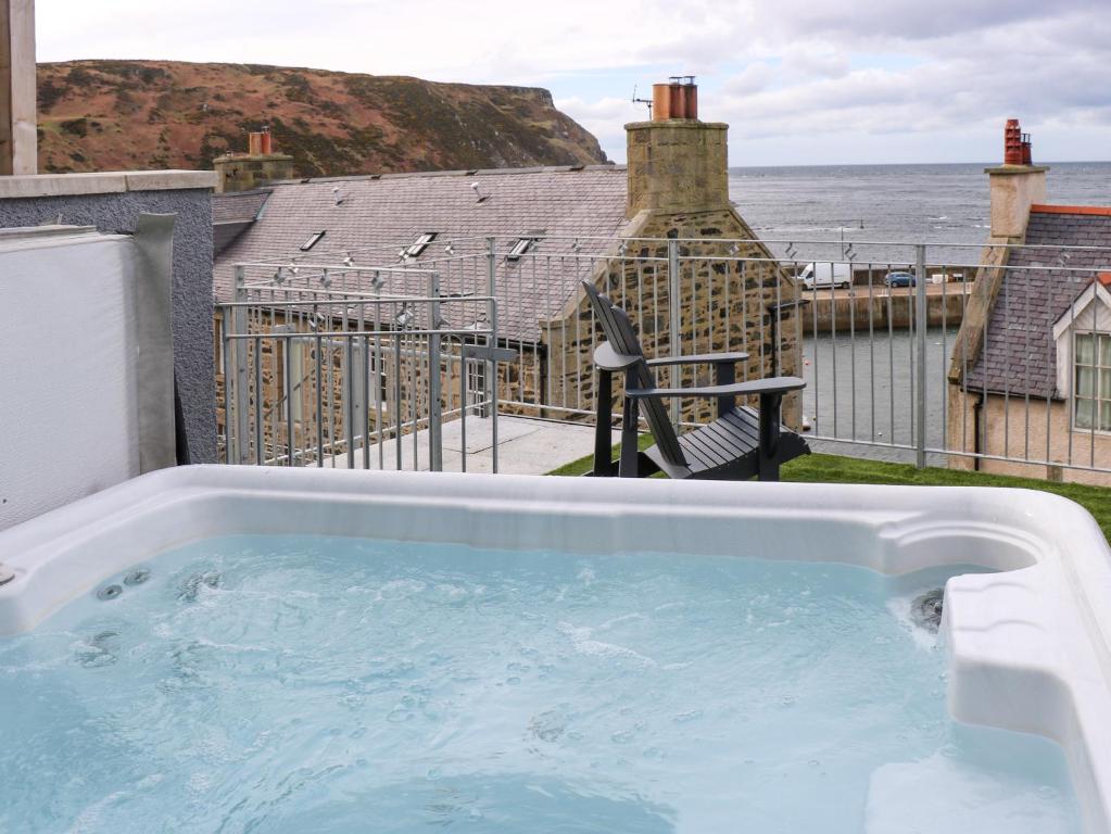 a hot tub on a balcony with a view of the ocean at Craignure in Banff