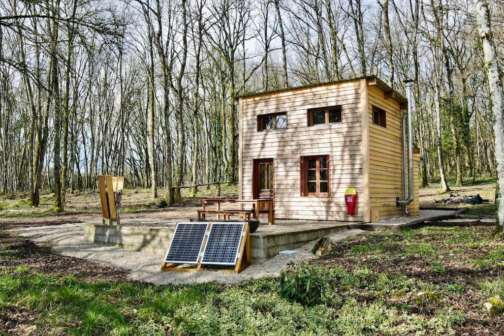 een klein huis met een zonnepaneel in het bos bij Cabane en forêt la mechta in Bologne