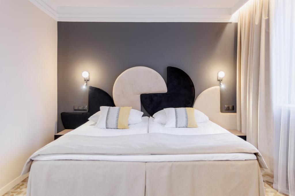 タルヌフにあるホテル ターノヴィアのベッドルーム(白いシーツを使用した大型ベッド1台付)