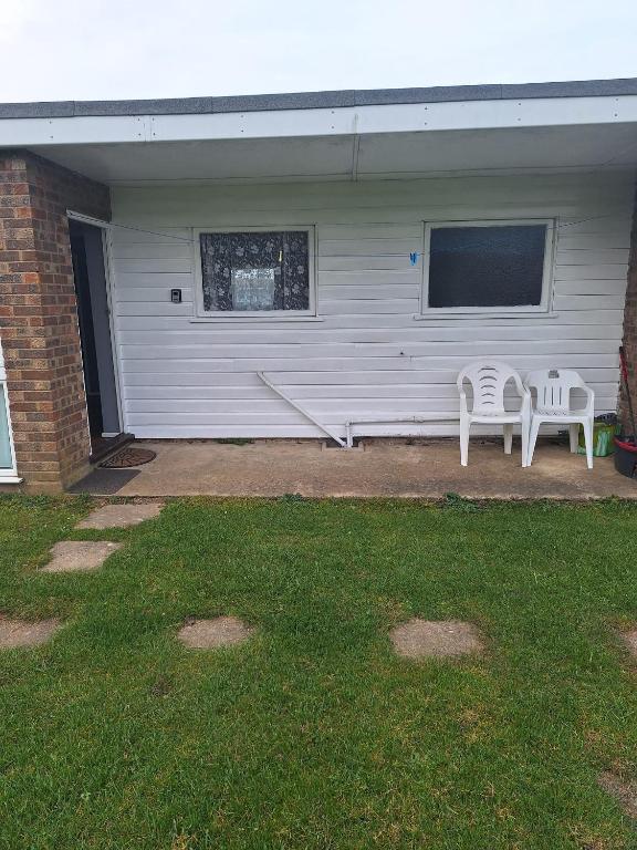 two chairs and a bench in front of a house at great holidays hemsby in Hemsby