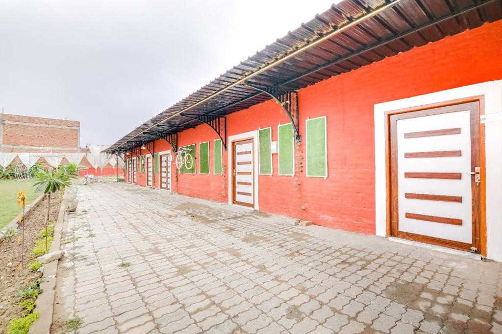 a row of red buildings with doors on them at OYO Flagship Aadya Greens in Juhi Bari