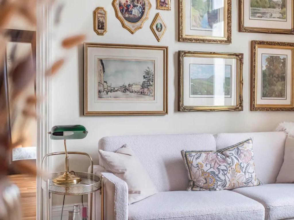 a living room with a white couch and pictures on the wall at Chic cosy Flat in Central London Pass the Keys in London