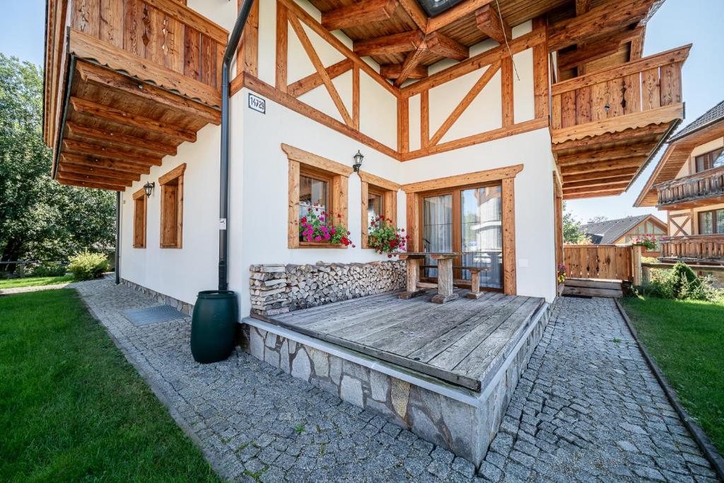 a home with a porch with a wooden roof at Tatrachalet Lomnica Rent in Vysoke Tatry - Tatranska Lomnica.