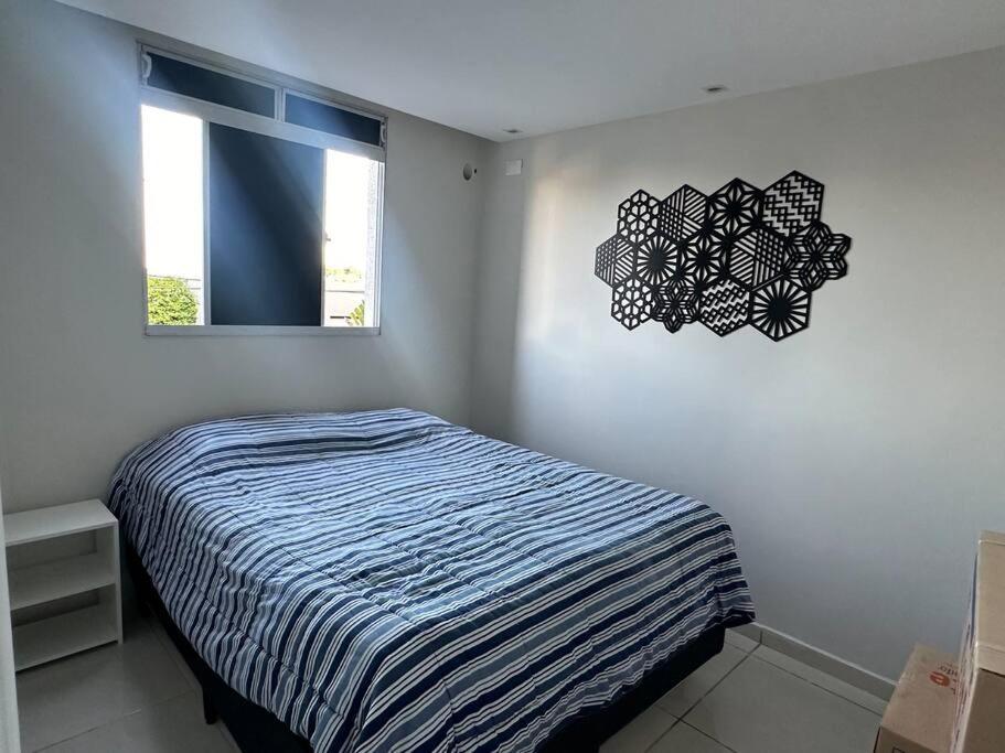 ein Schlafzimmer mit einem Bett und einer Uhr an der Wand in der Unterkunft Apartamento em João Pessoa in João Pessoa