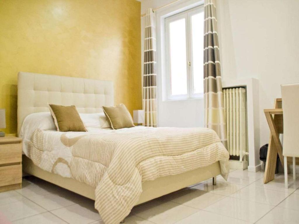a bedroom with a large white bed with a window at Hotel Citadelle in Béziers