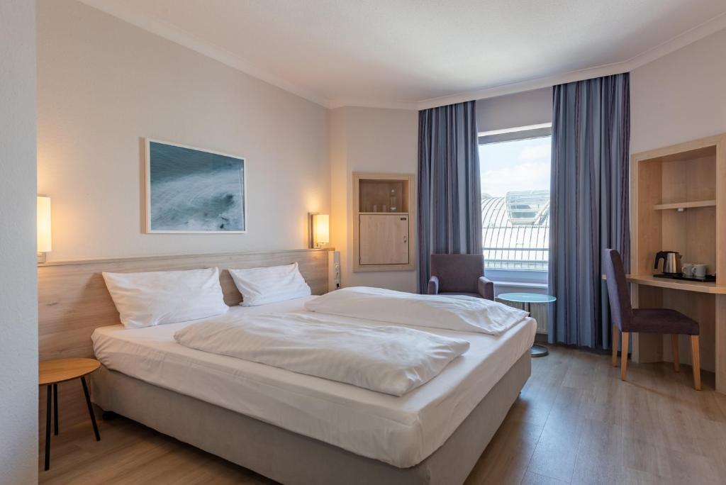 Postel nebo postele na pokoji v ubytování IntercityHotel Kiel