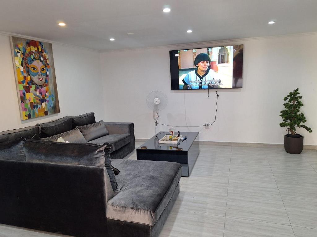 sala de estar con sofá y TV en la pared en Piscadera bay resort 15c, en Willemstad