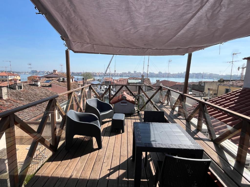 drewniany taras z krzesłami i stołami na balkonie w obiekcie Altana Deluxe Apart w mieście Chioggia