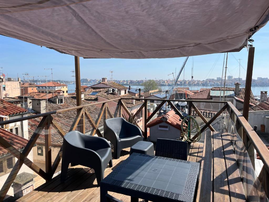 patio z krzesłami i stołem na balkonie w obiekcie Altana Deluxe Apart w mieście Chioggia