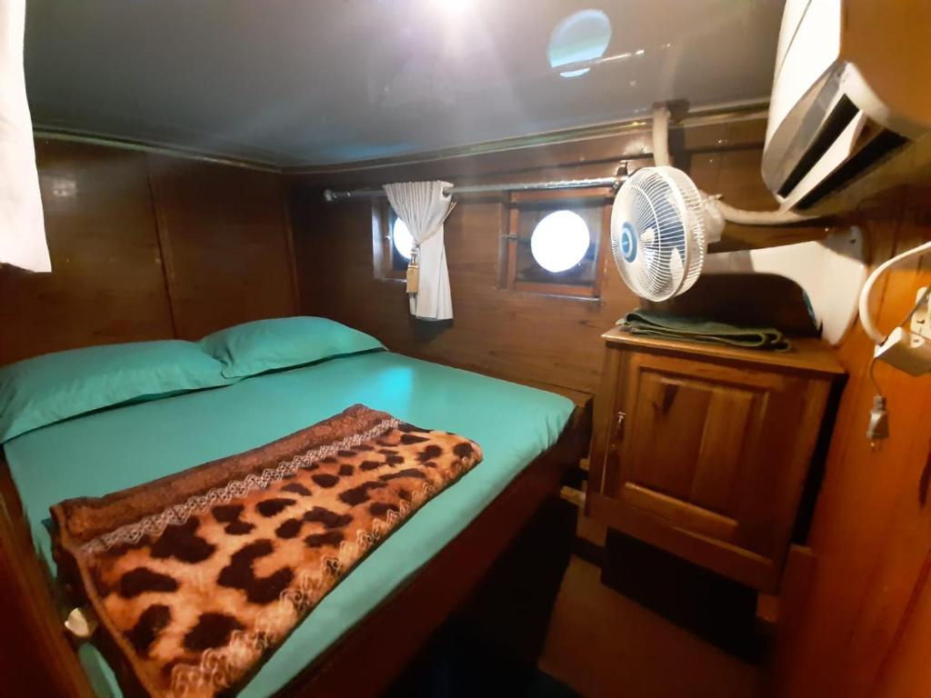 拉布安的住宿－Exploring komodo island，小房间设有一张床和一个风扇
