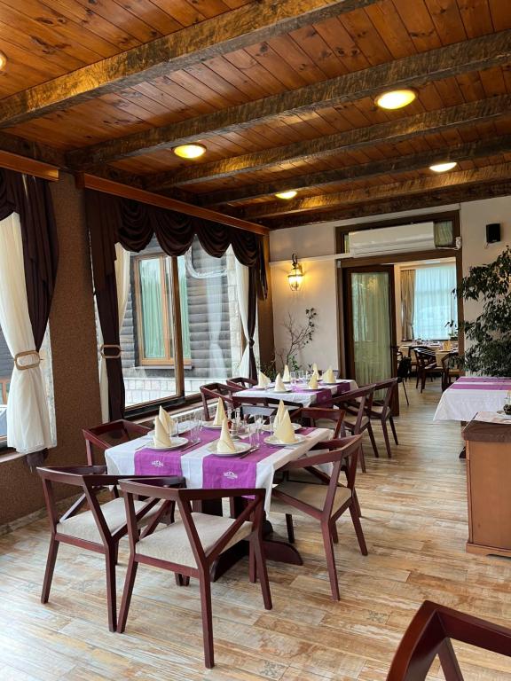 una sala da pranzo con tavoli e sedie in legno di Hotel Monte Rosa a Cetinje (Cettigne)