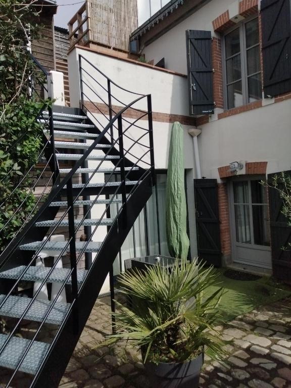 un escalier menant à un bâtiment avec des plantes en pot dans l'établissement Appartement T2 sur cour nantaise, à Rezé