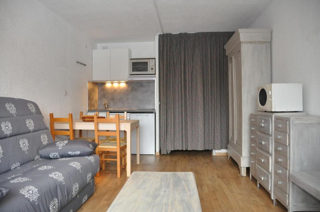 un salon avec un canapé et une table et une cuisine dans l'établissement Plein Sud - 2107 - Studio pied des pistes - 4 pers, à Les Deux Alpes