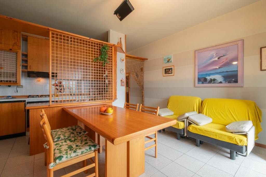 eine Küche und ein Esszimmer mit einem Tisch und gelben Stühlen in der Unterkunft Interno 18 in Clusane sul Lago